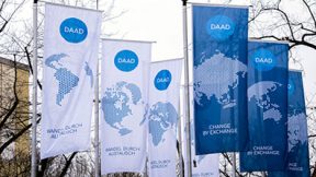 Flags with DAAD logo in front of the outer facade of the headquarters in Bonn.